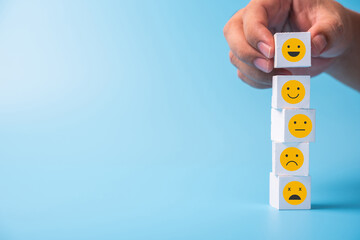 man putting smile face on the top of wood cube stack.Human resources and team management concept