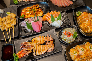 Japanese food set on the black plate in the restaurant.