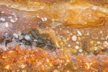 Texture of natural yellow-orange chalcedony with agate and fossils