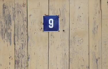 Vintage grunge square metal rusty plate of number of street address with number. Close up, brand.