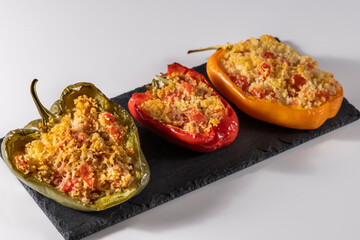 Cuscus, roasted peppers in the oven and stuffed with couscous with vegetables white background