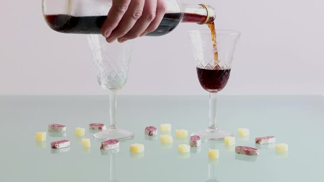 Mano de hombre sirviendo dos copas de vermut