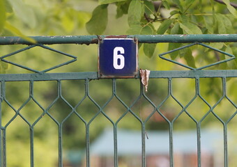 Vintage grunge square metal rusty plate of number of street address with number. Close up, brand.