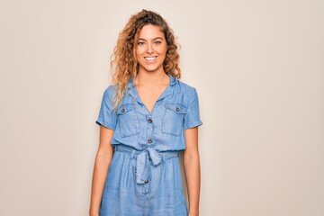 Obraz premium Young beautiful woman with blue eyes wearing casual denim dress over white background with a happy and cool smile on face. Lucky person.
