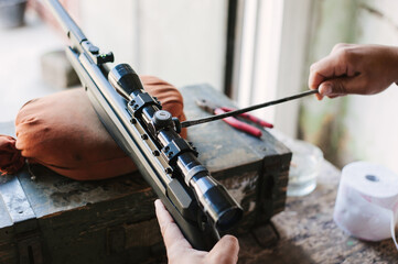 The gunsmith adjusts the optical sight of the sport air rifle. Adjusting the sniper rifle at a...