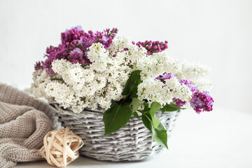 Spring composition with lilac flowers in a wicker basket.