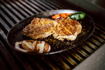 One piece of grilled steak with paprika and onion as side dish