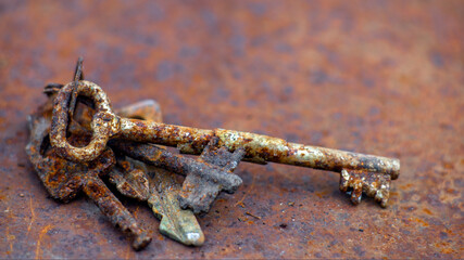 Several old rusty keys on ring shot on steel textured background