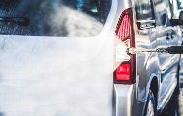 Manual car wash. Cleaning car using high pressure water with soup.