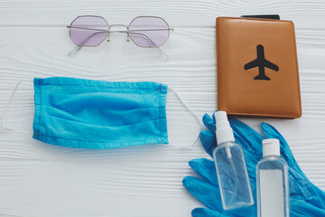 Coronavirus summer 2020. Blue face mask, gloves, antiseptic and disinfectant, passport, sunglasses...
