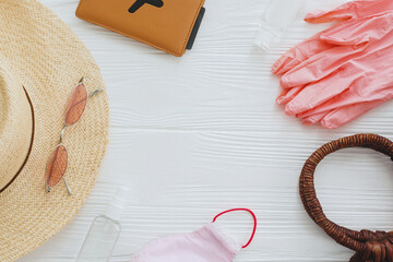 Coronavirus summer 2020. Pink face mask, gloves, antiseptic and disinfectant, passport,...