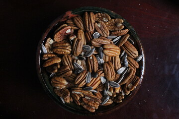 Bowl of pecans and sunflower seeds against a black background