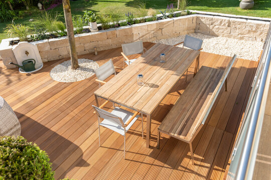 Teak furniture on a modern wooden terrace in summer
