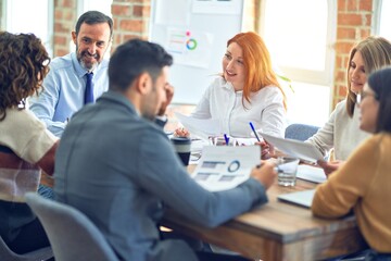Group of business workers working together. Sitting on desk using laptop reading documents at the office