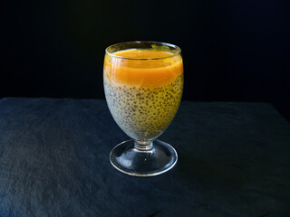 milk dessert with Chia seeds and mango on a dark background