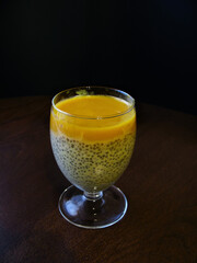 milk dessert with Chia seeds and mango on a dark background