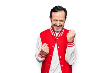 Middle age handsome man wearing baseball jacket over isolated white background celebrating surprised and amazed for success with arms raised and eyes closed