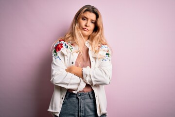 Young beautiful blonde woman wearing casual jacket standing over isolated pink background skeptic and nervous, disapproving expression on face with crossed arms. Negative person.