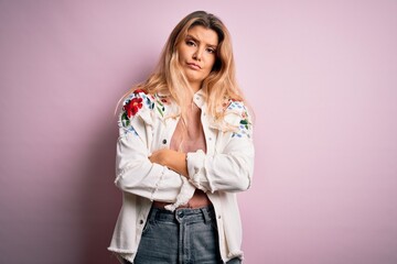 Young beautiful blonde woman wearing casual jacket standing over isolated pink background skeptic...