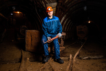 Male miner in uniform in a mine tunnel