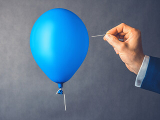Blue balloon. Man hold needle directed to air balloon. Concept of risk. Copy space. - 354155051