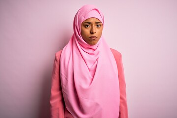 Young African American afro woman wearing muslim hijab over isolated pink background depressed and worry for distress, crying angry and afraid. Sad expression.