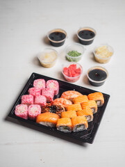 Set of sushi rolls in delivery plastic boxes on white background