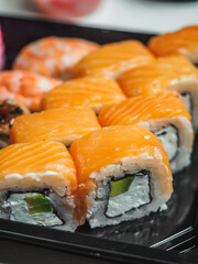 Set of sushi rolls in delivery plastic boxes on white background