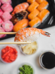 Sushi with prawn shrimp rice in wooden chopsticks