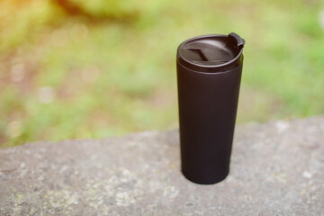 Black thermo cup on the street. Eco friendly