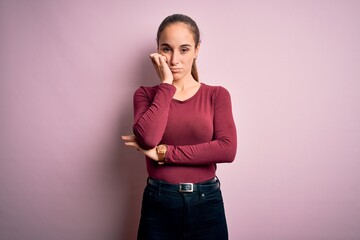 Young beautiful woman wearing casual t-shirt standing over isolated pink background thinking...
