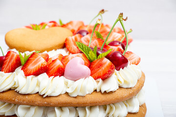 Homemade numbers cake with white cream strawberries and cherries