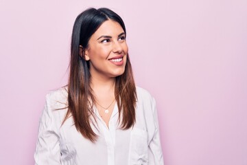 Obraz premium Young beautiful brunette woman wearing elegant shirt standing over isolated pink background looking to side, relax profile pose with natural face and confident smile.