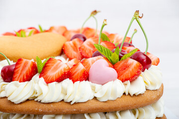 Homemade numbers cake with white cream strawberries and cherries