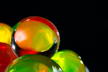 multi-colored silicone gel balls in a glass on a black background