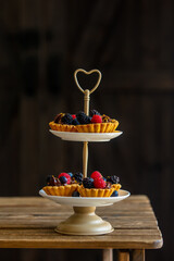 tartlets with berries and chocolate cream on a stand