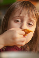 Portrait of little cute child girl eating pancake