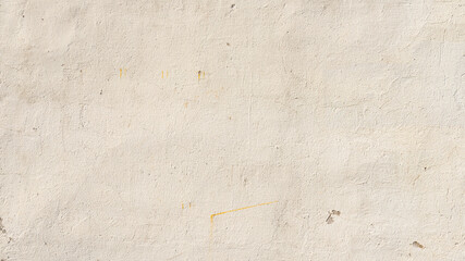Beige painted wall texture, grungy background with some stains and small cracks.