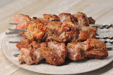 pork skewers on skewers in a plate on a wooden background