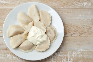 Fototapeta na wymiar dumplings with sour cream on a plate