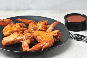 fried marinated chicken wings on a black plate