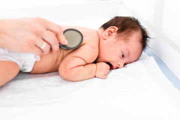 Doctor using a stethoscope to listen to kid's chest checking heartbeat