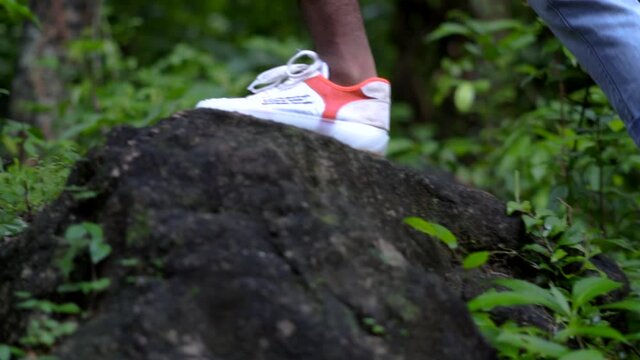 young man in forest walking on rocks woods with backpack concept travel tourism
