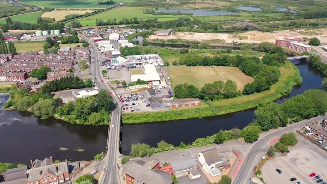 Aerial footage of the village centre of Castleford in Wakefield, West Yorkshire, England showing the main street along side the River Aire on a bright sunny summers day