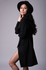 Elegant and chic asian model in black coat and hat.