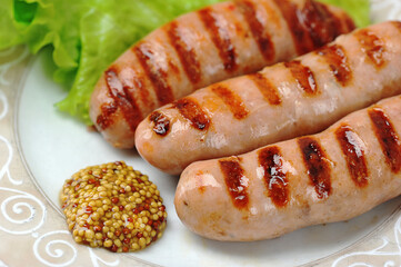 grilled fried wurst on plate with salad leaves and peppers