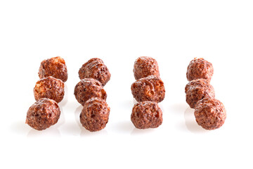 Chocolate corn balls isolated on white background. Chocolate balls dry breakfast scattered on a white background. Space for text. Also known as Chocolate flakes. Full depth of field.