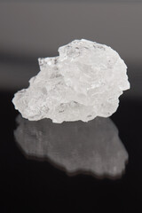 rock salt crystal over dark background.  outer space. vertical orientation.
