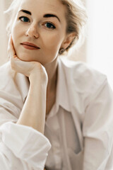 Portrait of a blond wavy-haired young confident and successful girl. Youth, lifestyle and happiness concept. A photo with a blurred background.