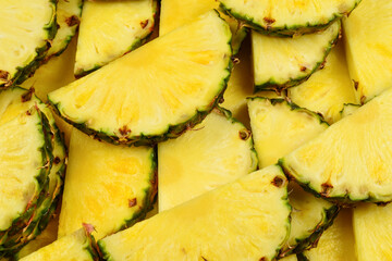 Pineapple juicy yellow slices background. Top view.